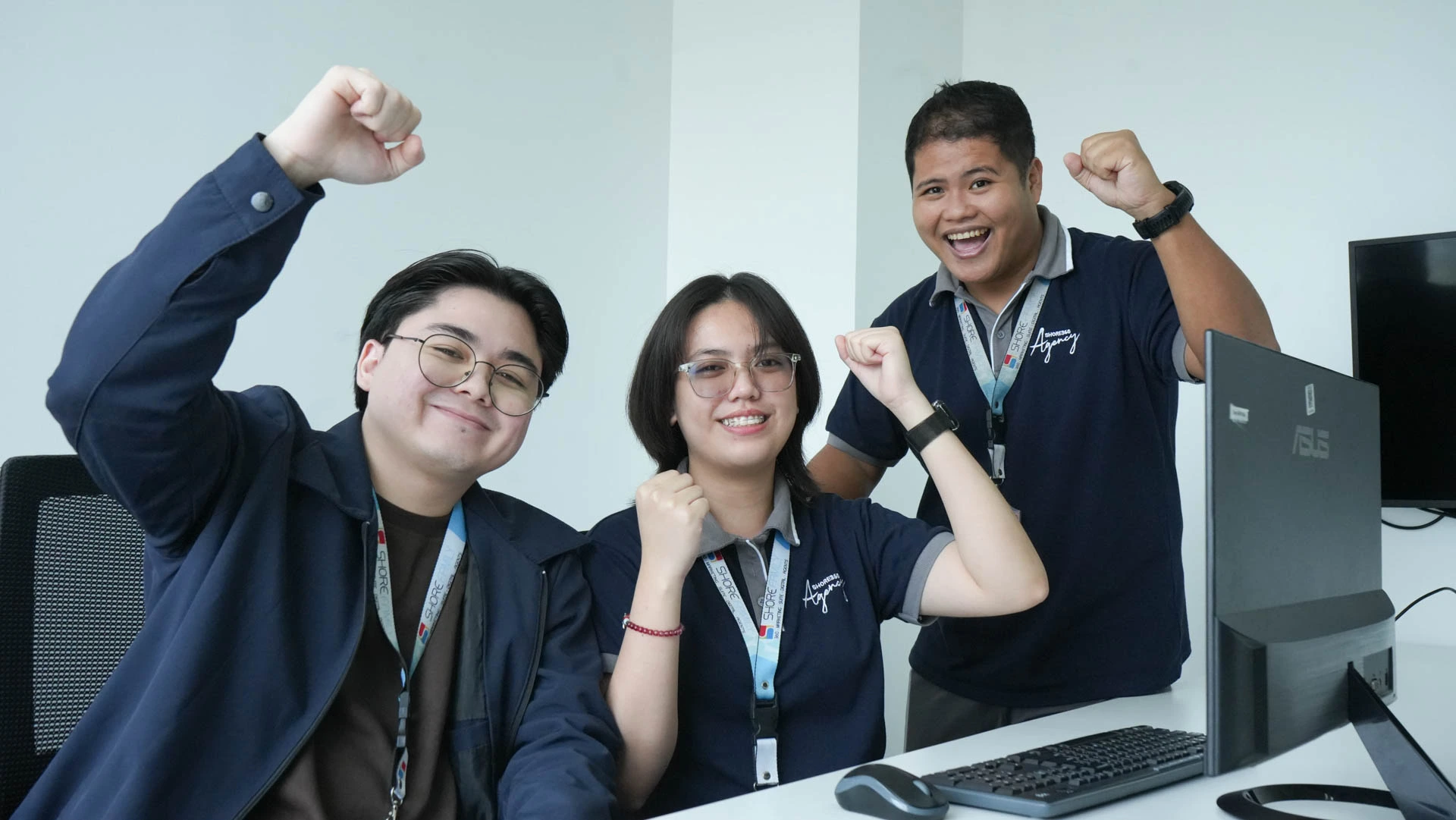 Enthusiastic team members celebrating an achievement in a professional office setting.